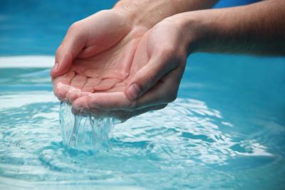 Hands lifting water and letting it flow back down